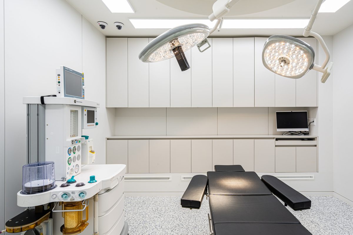 Operating room with two surgical lights, cabinetry, and a wall monitor