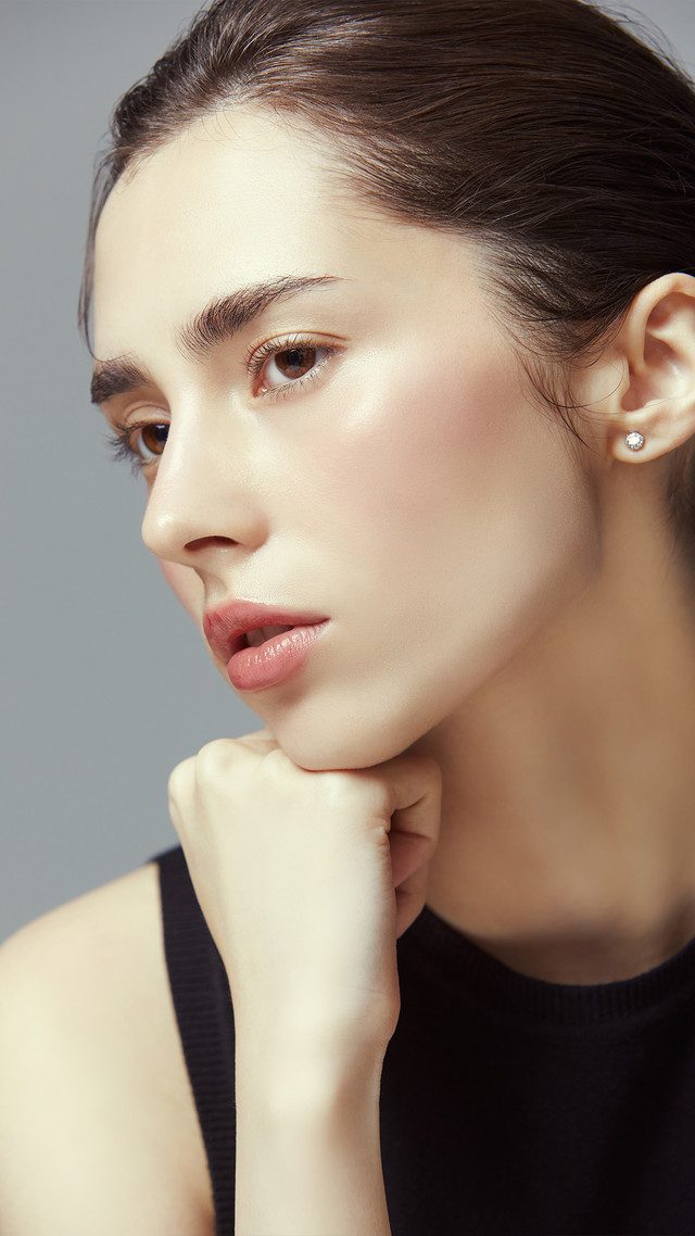 Close-up photo of a woman resting her chin on her hand