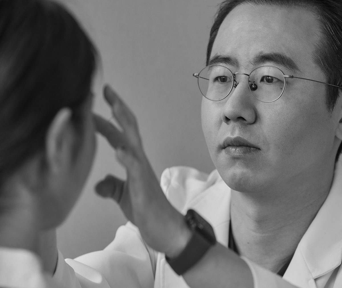 성형외과 전문의가 환자의 코 상태를 촉진하며 진찰하는 모습